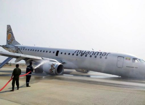 Petugas pemadam kebakaran melakukan penyemprotan pemadam untuk mengamankan pesawat Myanmar National Airline (MNA), yang mengalami kecelakaan di bandara Internasional Mandalay, Myanmar, Minggu (12/5). (Foto: AP/Arab News)