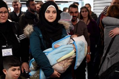 Seorang wanita Suriah menggendong bayi ketika sejumlah pengungsi Suriah tiba di bandara internasional Fiumicino Roma Rabu 27 November 2019. (Foto: AFP/Arab News)