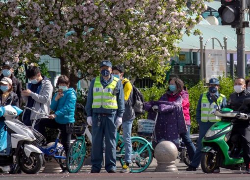 Orang-orang berhenti di persimpangan saat momen berkabung nasional untuk para korban coronavirus di Beijing pada hari Sabtu (4/4). (Foto: AP/Al Jazeera)