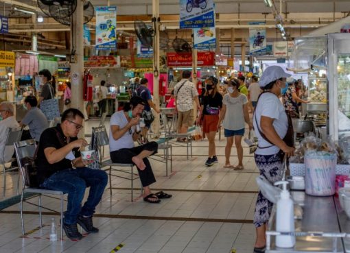 Orang-orang berupaya menjaga jarak sosial duduk dan makan di sebuah pasar di Bangkok, setelah pembatasan dilonggarkan minggu ini.(Foto: AP/Al Jazeera)