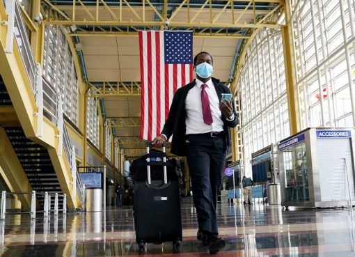 Seorang penumpang berjalan di Bandara Nasional Reagan di Washington, DC. Pihak Airlines menyatakan, penumpang bisa dilarang jika mereka menolak untuk memakai masker wajah. (Foto: Reuters/Al Jazeera)