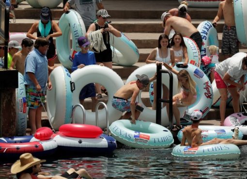 Sejumlah orang, termasuk anak-anak, bersiap mengarungi Sungai Comal di Texas meskipun terjadi lonjakan baru-baru ini dalam kasus COVID-19. (Foto AP/Al Jazeera)