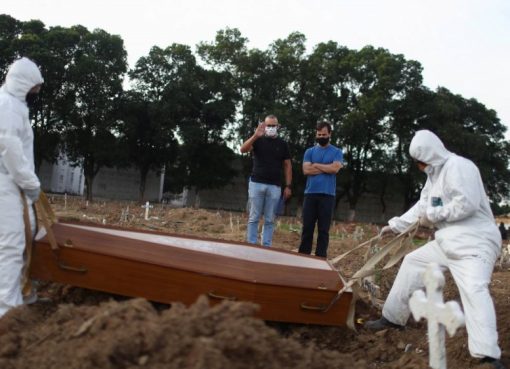 Dua bersaudara Carlos Alexandre dan Wagner Cardninot, menghadiri pemakaman ayah mereka, Jose Herminio de Farias, 76 tahun, Sabtu lalu, yang meninggal karena COVID-19 di Rio de Janeiro, Brazil. (Foto Reuter/Al Jazeera)