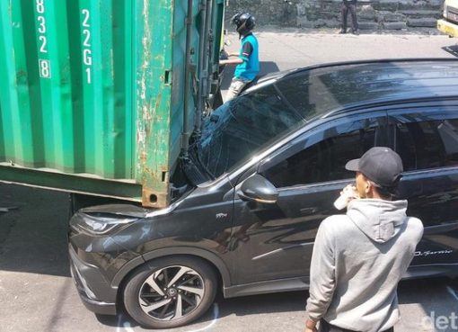 Truk membawa kontainer tersangkut jembatan terjadi di Kota Bogor, Jabar. Kontainer yang dibawa truk tersebut meniban mobil yang melaju di belakangnya.