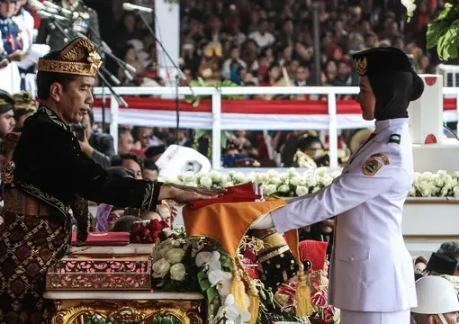 Presiden Joko Widodo menyerahkan duplikat bendera pusaka kepada Paskibraka Salma El Mutafaqqiha dalam Upacara Peringatan Detik-Detik Proklamasi Kemerdekaan Indonesia ke-74 Tahun 2019 di Istana Merdeka, Jakarta, Sabtu (17/8/2019).