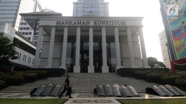 Personil Brimob berjalan melintasi halaman depan Gedung Mahkamah Konstitusi, Jakarta, Kamis (13/6/2019).